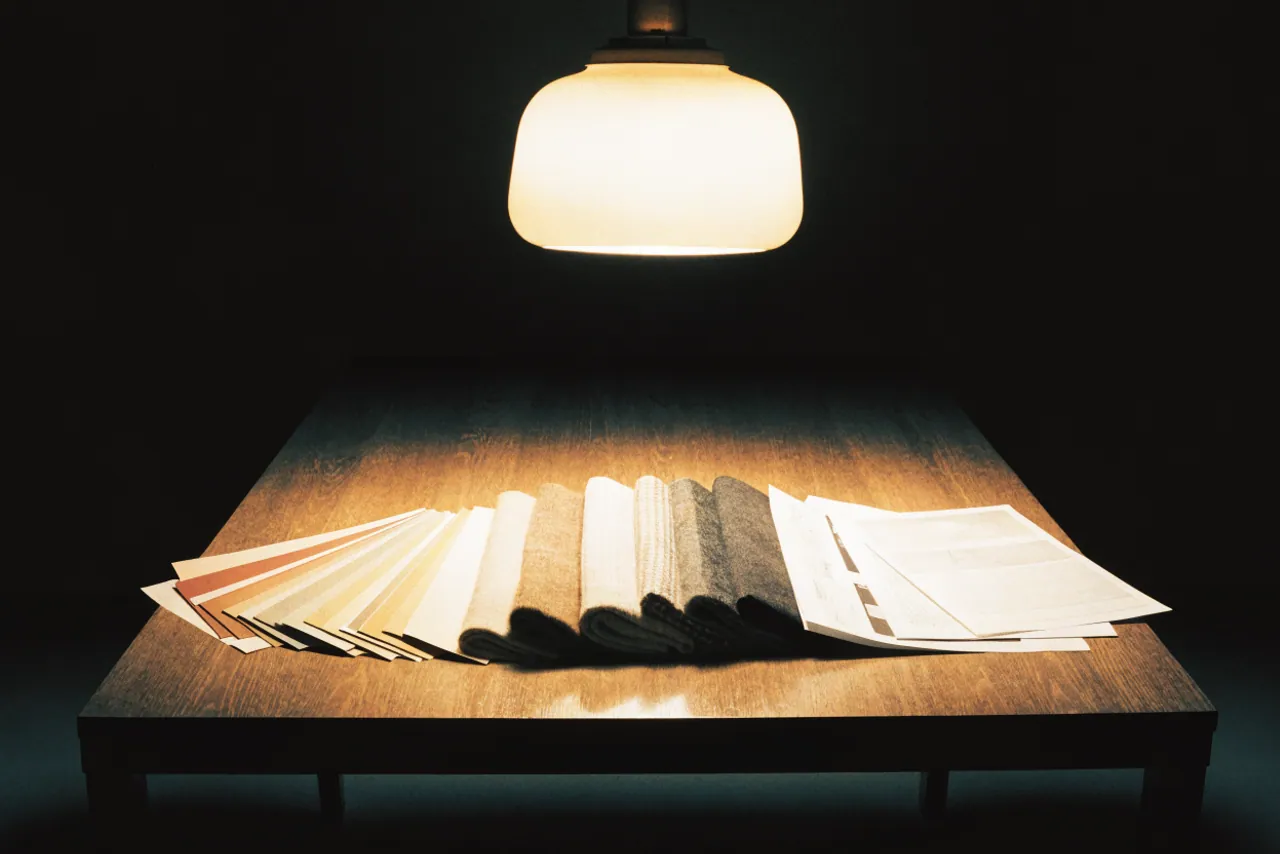 Farbfächer, Stoffmuster und Schriftmuster auf demselben Tisch